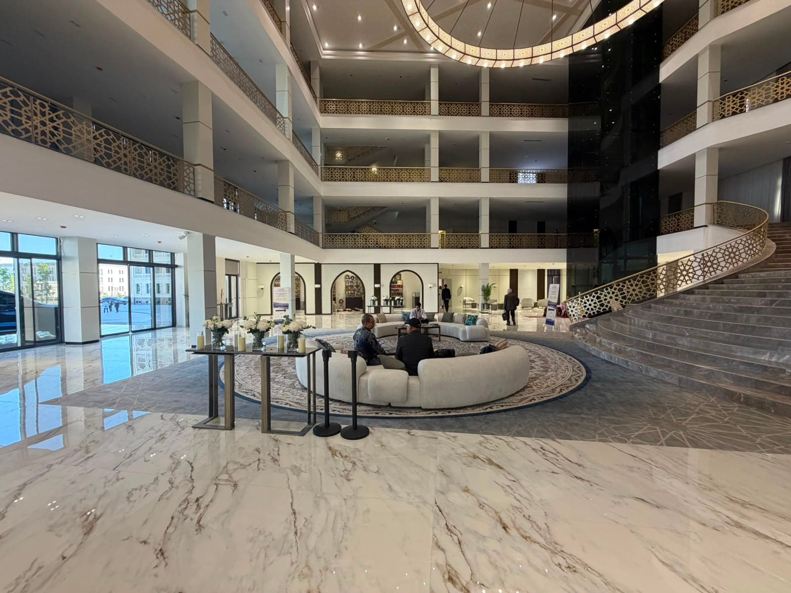 The grand lobby of Hadith Hotel, with marble floors and a sweeping staircase