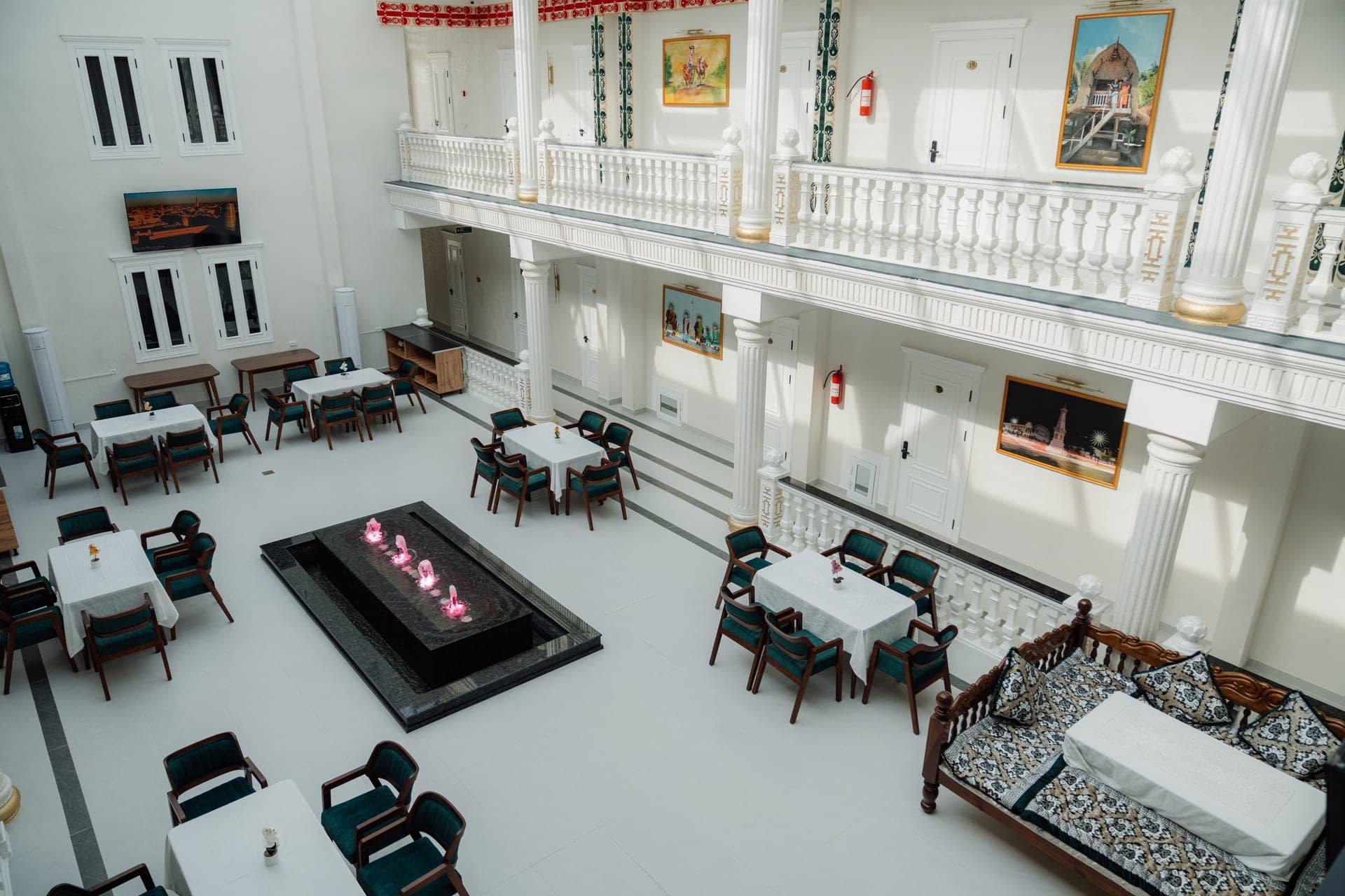 Wide view of the Kampoeng Indonesia restaurant atrium with fountain and set tables, Samarkand